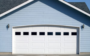 Arched garage door opening on new home with blue siding