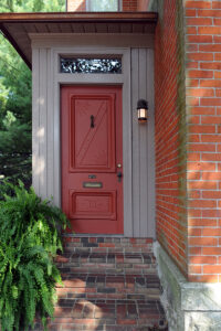An inviting front door of an old urban brick home