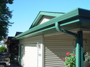 Green gutters installed on white home